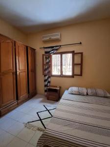 Un dormitorio con dos camas y una ventana. en Mango House, en Saly Portudal