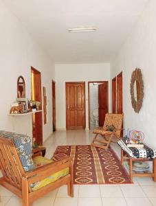 Una sala de estar con dos sillas y una alfombra. en Mango House, en Saly Portudal