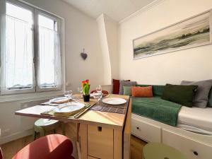 ein Wohnzimmer mit Tisch und Bett in der Unterkunft Primavera : Beau 2-pièces proche Paris, RER B 450m in Gentilly