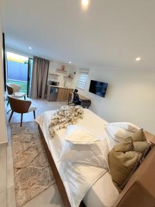 a bedroom with a large bed and a living room at DOMIN LUXURY SUITES in Cape Town