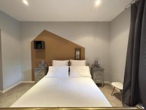 a bedroom with a large bed with white sheets at Aperegina in Castellinaldo