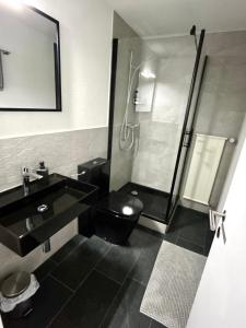a bathroom with a shower and a black toilet and sink at Panorama Lakeside Retreat Seelisberg in Seelisberg