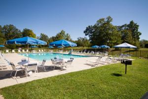 a swimming pool with chairs and blue umbrellas at Club Wyndham Resort at Fairfield Glade in Fairfield Glade