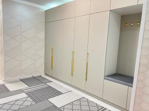 un dressing avec des armoires blanches et un miroir dans l'établissement Жана кала 3 комнатная квартира, à Tridtsatʼ Let Kazakhstana 25 autres photos