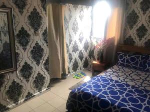 a bedroom with a blue bed and a window at Studio à Ydé Bastos in Yaoundé