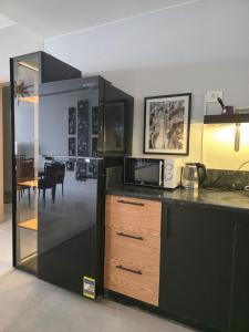 a kitchen with a counter with a microwave and a table at The view in Banī Ghālib