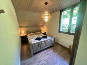 ein Schlafzimmer mit einem Bett und einem Kronleuchter in der Unterkunft Chalet 4 6 Pers Climatisation Proche St Francois in Saint-Martin-sur-le-Chambre