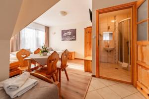 a room with a table and chairs and a bathroom at Willa Leśny Potok in Poronin