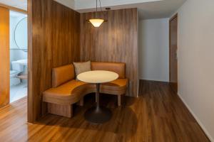 a room with a table and a bench with a table at Estanplaza International in Sao Paulo