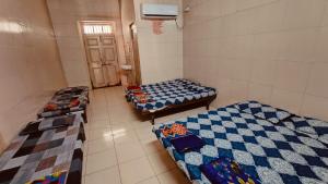 una habitación con tres camas en una habitación en DYO Agrasan Bhavan, en Dwarka