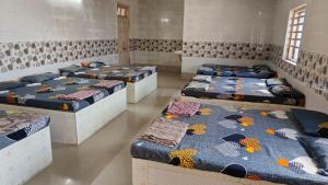 Habitación con 4 camas seguidas en DYO Agrasan Bhavan, en Dwarka