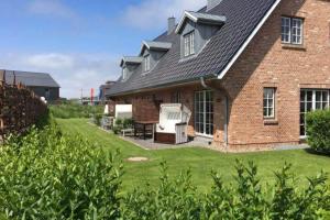 a brick house with a patio and lawn at Endless Summer mit Sauna, Hörnum, Sylt - 1 Hund willkommen in Hörnum