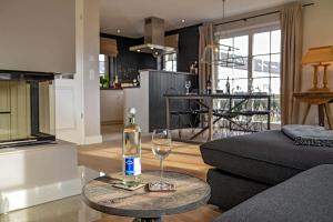 a living room with a bottle of wine on a table at Monkey Island mit Sauna, Hörnum, Sylt - 1 Hund willkommen in Hörnum