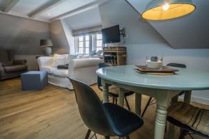 a living room with a table and a couch at Suite Anno 1792-OG im Klenterhof, Westerland, Sylt - 1 Hund willkommen in Westerland