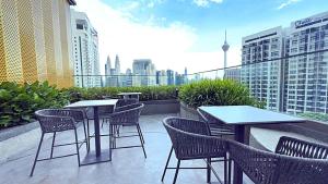 a patio with tables and chairs on top of a building at Majestic Residence Suites KLCC in Kuala Lumpur