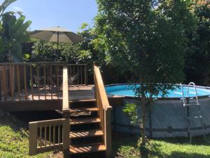 un ponte di legno accanto a una piscina con un ombrellone di Casa de campo María Isabel a Montitlán