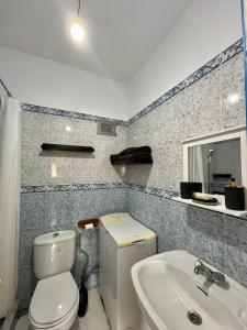 a bathroom with a toilet and a sink at Appartement bord de mer in Jbila
