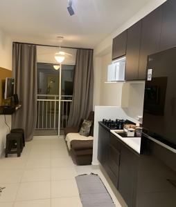 圣保罗1702 Expo Transamérica - Vista para Represa - Varanda的带沙发的客厅和带炉灶的厨房。