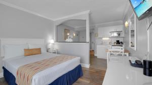 a hotel room with a bed and a kitchen at Pelican Pointe Clearwater Beach Hotel in Clearwater Beach