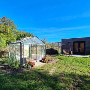 a greenhouse in the yard of a house at New! Tiny House Lantliv Oostkapelle, met weidezicht in Oostkapelle +30 photos