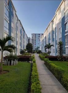 un trottoir devant des bâtiments avec des arbres et des buissons dans l'établissement Chilacoa Rooms, à Armenia
