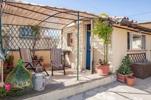 a patio with two chairs and a table with plants at The Terrace of San Pellegrino - Historic Center in Viterbo