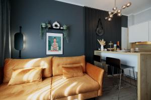 Una sala de estar con un sofá y una cocina. en Baltic 4YOU 3, en Pobierowo