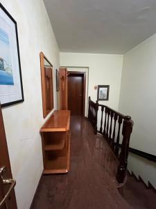 een gang met een houten tafel en een trap bij La Tana della Volpe B.&.B. in Montecassiano