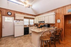 cocina con electrodomésticos blancos y paredes de madera en M.S. Whaley, en Edisto