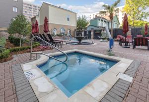 a swimming pool with a hose in a courtyard at Club Wyndham Avenue Plaza in New Orleans
