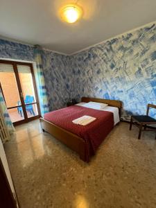 a bedroom with a bed with a red comforter at La Tana della Volpe B.&.B. in Montecassiano