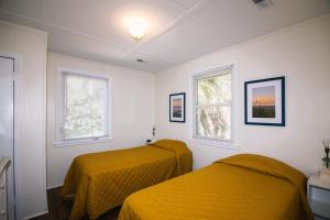 duas camas em um quarto com lençóis amarelos em Rich Tymes em Edisto Island
