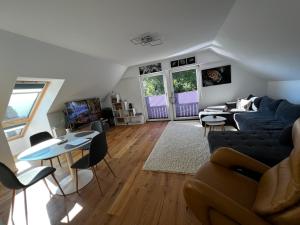 een woonkamer met een bank, een tafel en stoelen bij Traum Berg - Koppelberg in Traben-Trarbach