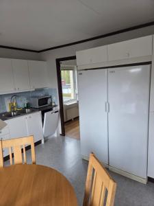Anebyにある4-person apartment in Anebyのテーブル付きのキッチンと白いキャビネット付きのキッチン +2枚の写真