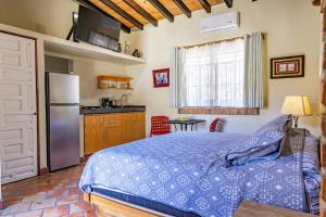 a bedroom with a bed and a kitchen with a refrigerator at Suite Amapas in the heart of Romantic Zone in Cedro +24 photos