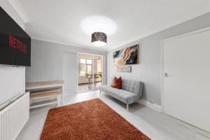 a living room with a couch and a window at Lesley House 4 bed villa TV Internet Garden in Gillingham