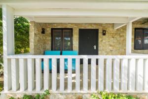 Kokomo Ultra-Lux King - Single Cottage في ترتل كوف: شرفة بيضاء مع كراسي زرقاء عليها