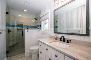 a bathroom with a toilet and a sink and a mirror at A Shore Investment in Edisto Island +42 photos