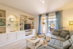 a living room with a couch and a tv at Gaia - Villas de Bolonia in Aduanas
