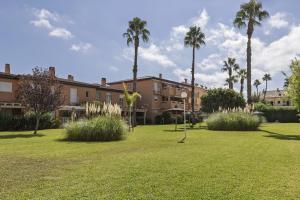 a park with palm trees and a building at Gaia - Villas de Bolonia in Aduanas