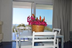una mesa de comedor con una cesta de flores. en Lu rusciu te lu mare, en Maruggio