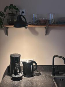 a kitchen counter with a coffee maker on a stove at B&B de Perenboom in Eck en Wiel