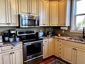 una cucina con mobili bianchi ed elettrodomestici neri di Tipsy Turtle a Captiva