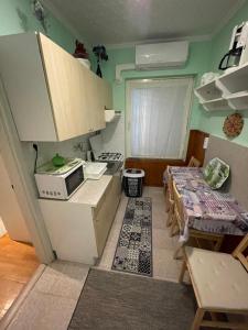 a small kitchen with a stove and a table at Balaton-Lak Apartmanház in Siófok