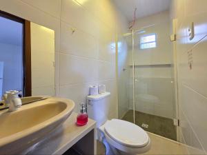a bathroom with a sink and a toilet and a shower at Casa 10 min do centro com wifi e garagem in Foz do Iguaçu +24 photos