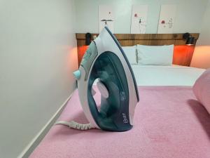 a washing machine sitting on the floor next to a bed at Casa 10 min do centro com wifi e garagem in Foz do Iguaçu