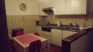 een keuken met witte kasten, een wastafel en een tafel bij Casa Marina in Fosdinovo