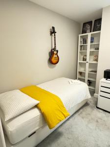 ベティーズタウンにあるCozy Coastal Home Bettystownのベッドルーム1室(壁にギター付きのベッド1台付)
