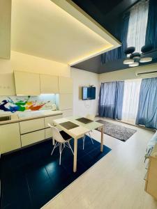 Квартири подобово центр في دنيبروبيتروفسك: مطبخ مع طاولة وكراسي في الغرفة