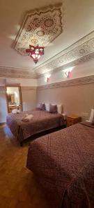 Pokój hotelowy z 2 łóżkami i żyrandolem w obiekcie Riad Arbre Bleu w Marakeszu